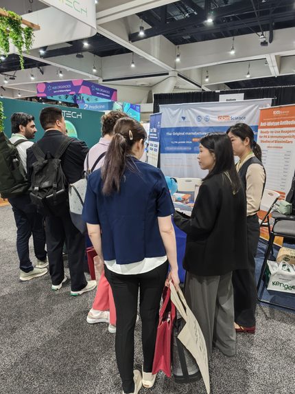 Researchers visiting AtaGenix booth at AACR 2026